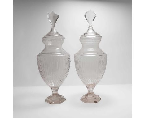 A pair of clear glass vases and covers, 20th century, urn shaped, on stepped hexagonal plinths, 63cm high (2)