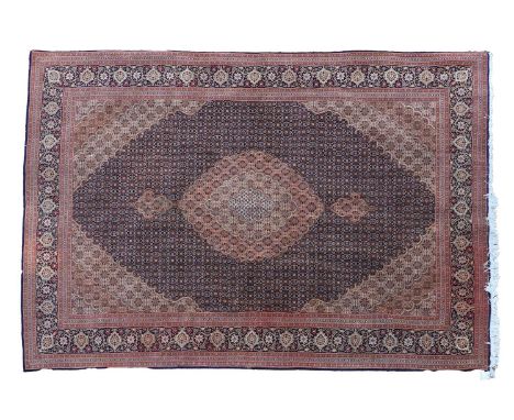 A Tabriz wool carpet with geometric motifs to a red ground,302 x 199cmCondition ReportWear, some marks and slight fading. Str