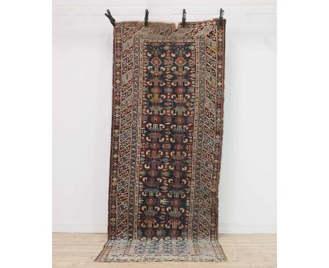 A Caucasian wool runner, late 19th century, possibly Kuba, with repeating motifs to a navy field,330 x 120cmCondition ReportV