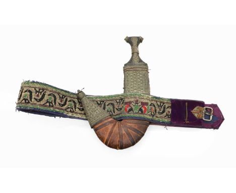 A Yemeni dagger or jambiya  with rhino horn handle, with leather sheath mounted with filligree white metal, and embroidered b