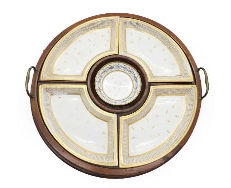 A mahogany sectioned serving tray, with brass handles, 50.5cm diameter, with a matched set of porcelain dishes, c.1785, Frenc