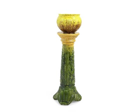 A Victorian jardinière and stand c.1880, the green, amber and yellow glazed body with scrolling leaf and flowerhead decoratio