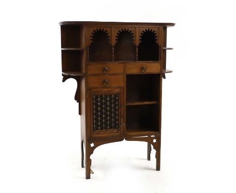 A mahogany cabinet, c.1900, in the Moorish taste, with shelves either side a triple arcaded shelf, over three drawers, a cupb