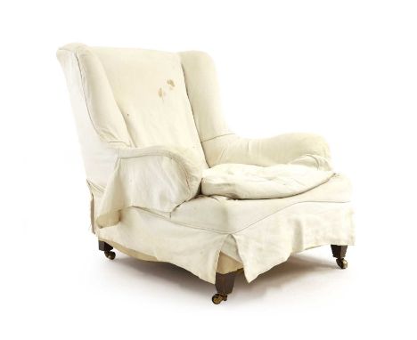 A Victorian wing armchair late 19th century, in the manner of Howard and Sons, with roll arms and deep seat, on tapering beec