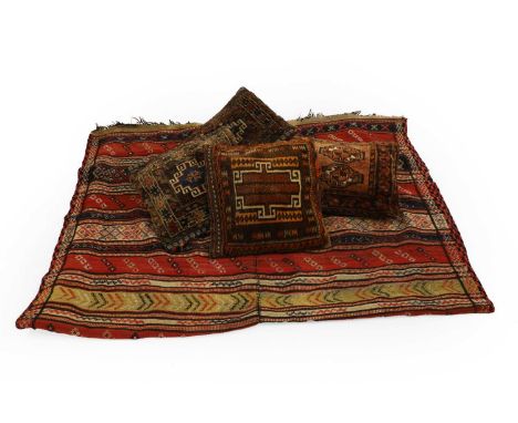 A Kilim rug 20th century, reapting motifs to a earthy striped ground,225 x 139cm,together with four saddlebag cushions,the la