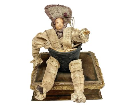 Modern reproduction automaton in the form of a baby doll in a basket clothed in Victorian style lace bloomers and frilled bon