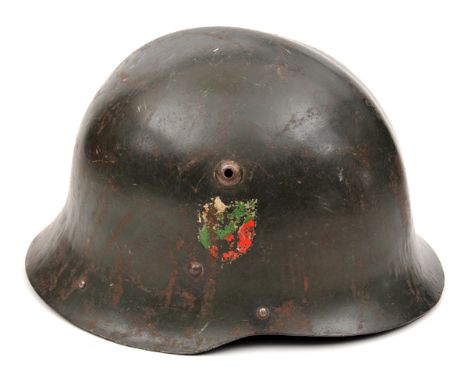 An Eastern European steel helmet,  the dark grey/green skull with low medial ridge and with white/green/ red national shield,