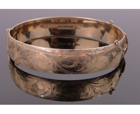 A 9ct gold engraved hinged bangle,35g.