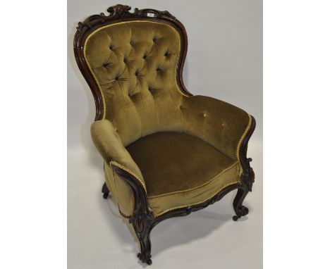 A Victorian button upholstered armchair,with carved showwood surround.