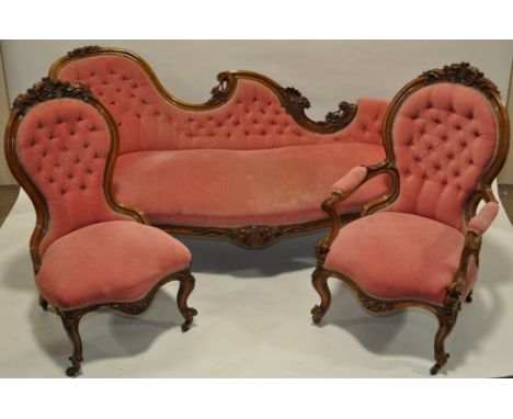 A Victorian carved walnut framed button upholstered salon sofa,with matching open armchair and nursing chair.