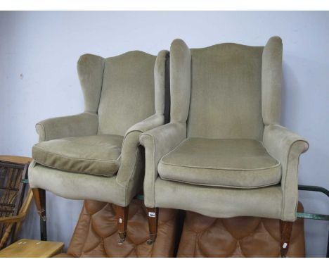 An Early XX Century Arnmchair, upholstered in a light greeb velvet fabric, on tapering legs with brass castors; another simil