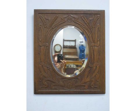 Arts &amp; Crafts Oak Framed Oval Bevelled Wall Mirror, hand carved and pokerwork with stylized wheat sheaves, dated 1912 and