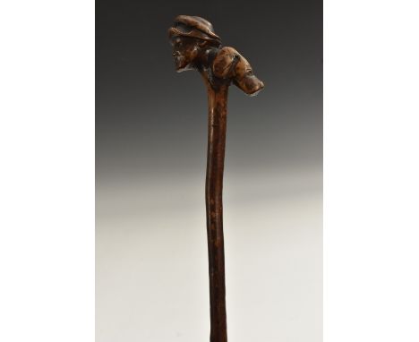 A 19th century folk art walking stick, the handle carved as a huntsman and his hound, 79cm long