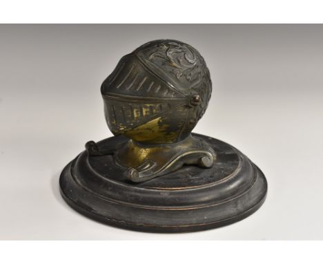 A 19th century novelty inkwell, as a knight's helmet and visor, turned ebonised base, 14cm diam, c.1880