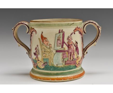 A 19th century English pottery loving cup, moulded in relief with a Punch and Judy show, to verso with Tobias sitting for a p