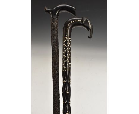 An Anglo-Indian ebony gentleman's walking stick, profusely carved in shallow relief with scrolling foliage and flowering stem