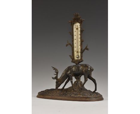 A 19th century cast iron table thermometer, as a stag grazing beside a tree, oval base, 22cm wide, c.1870