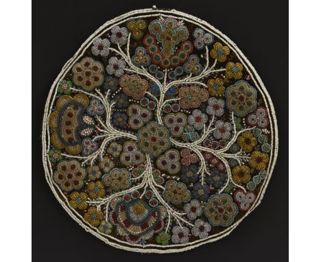 A circular beadwork panel, colourfully worked with stylised flowering branches, 19cm diam