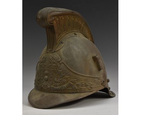 A 19th century French fireman's helmet, of typical form, the front cast with a grenadier's trophy, ribbon apron inscribed Srs