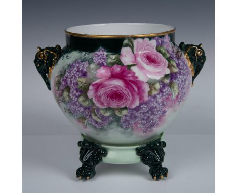 A beautiful green planter with a matching base, adorned with charming pink roses and violets. This exquisite piece showcases 