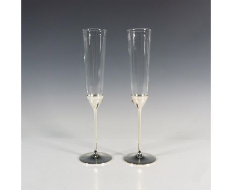 Two exquisite glasses crafted from glass and silver-toned metal, adorned with decorative metal bows for an elegant touch. Thi