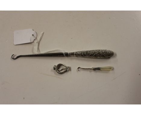 A late Victorian silver handled button hook, Birmingham 1899; together with a small folding silver button hook and another wi