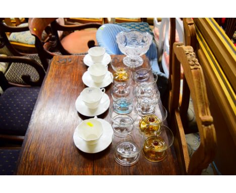 A set of four white glazed tea cups and saucers; ten glass sundae dishes; and a glass pedestal bowl 