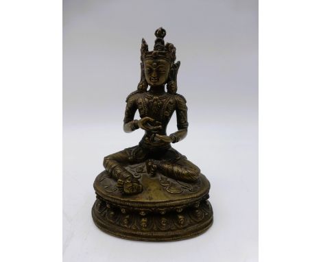 Thronende Tara, Tibet, Figur einer sitzenden Frau auf einer Lotosblüte, Messingbronze,Boden offen, h. 14,5cm, Gewicht: 464 g.