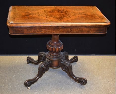 A Victorian walnut card table, folding top enclosing a baize lined playing surface, above a cockbeaded frieze, gadrooned balu