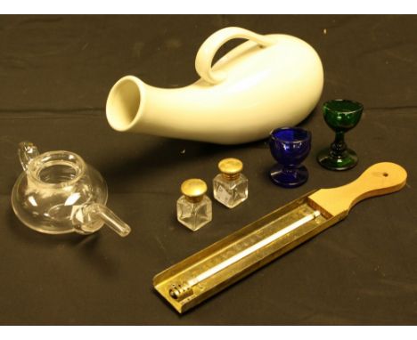 A 19th century clear glass invalid feeder; a green glass eye bath; another, blue glass; a thermometer; a bed urinal; smelling