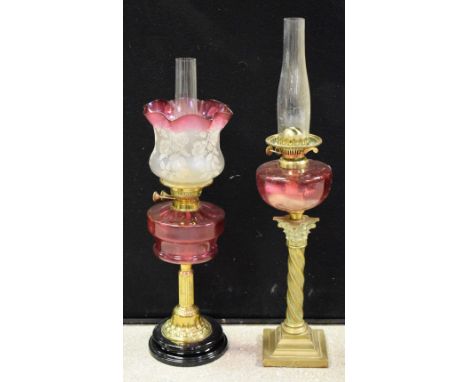 A Victorian brass and cranberry glass oil lamp, ornate floral shade; another similar (2) 