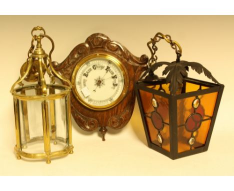 A brass shaped cylindrical ceiling lantern; another, stained glass; an oak shield shaped aneroid barometer (3)