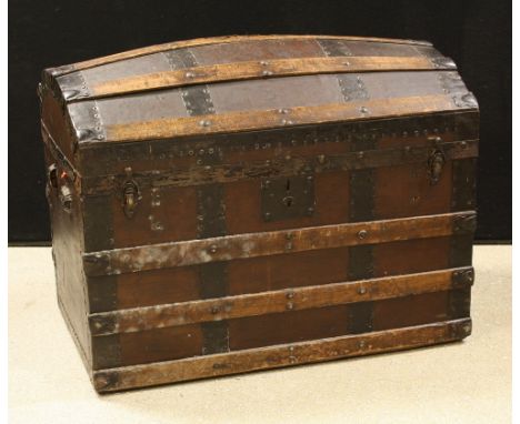 A domed wooden bound travelling trunk 
