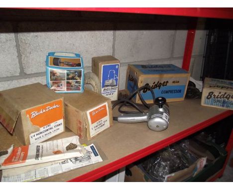 A vintage Black &amp; Decker drill with boxed attachments including Bridges compressor and spray gun.
