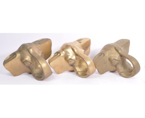 A collection of three brass elephant head bar rail holder brackets. Each bracket being in the form of an elephants head with 