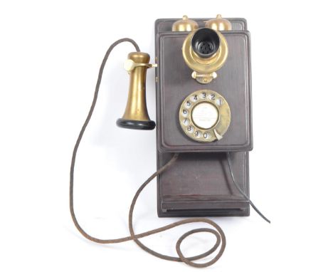 An early 20th century circa 1930s wall hanging telephone. The telephone having a mahogany wooden case, with brass dial, mouth