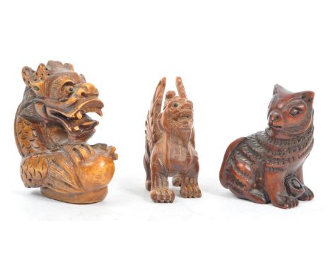 A collection of three 19th century Japanese netsuke carved wooden figures. Comprising of mythical creatures dragon, a standin