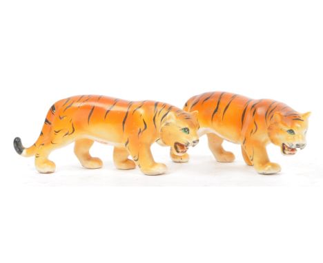 A pair of early 20th century circa 1930s Chinese porcelain hand painted tiger figures modelled in prowling position. Stamped 