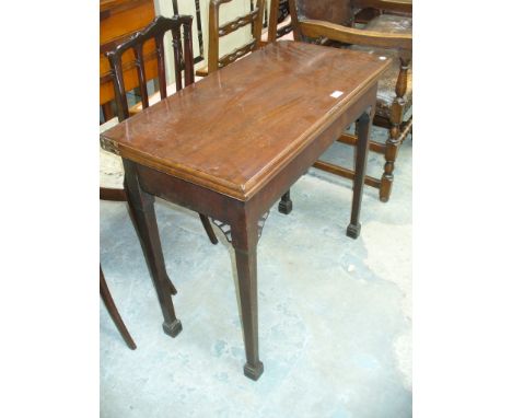 A 19th Century mahogany folding tea table on legs of tapering square section.