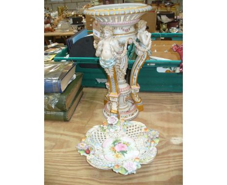 A Continental cherub figural table centre piece with an open work basket raised on three gilt embellished curvilinear support