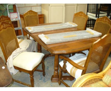 A Continental style extending dining table with 6 conforming rattan back chairs.