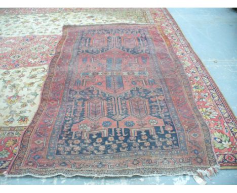 A Qashqai style rug
On a predominantly ruby red ground, the central field with varying geometric patterns and lozenges, ivory