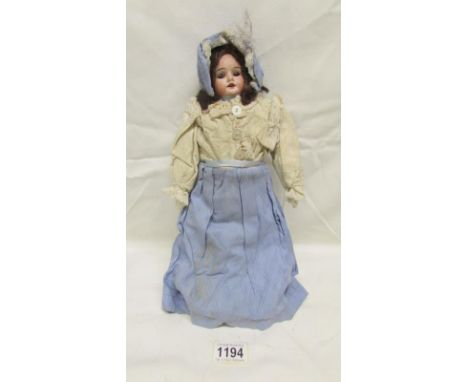 A 19th century bisque head doll, maker indistinct and partly covered with hair