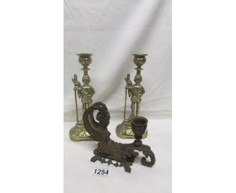 A pair of brass soldier candlesticks and a Victorian candlestick in the form of a mermaid