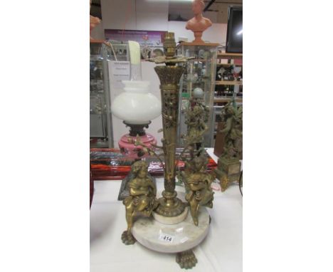 A large ormolu and marble table lamp with 2 seated cherubs