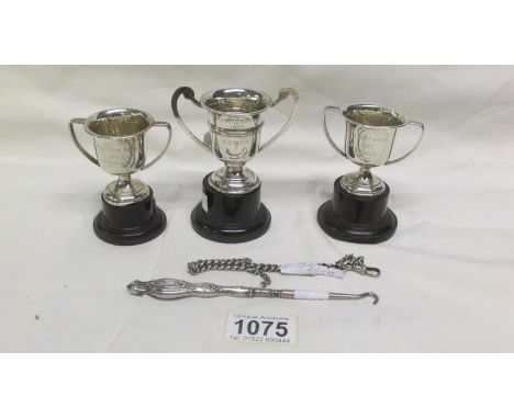 3 silver trophy cups with stands, a silver watch chain and a silver handled button hook