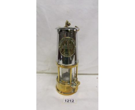 A polished brass and metal miner's lamp by Eccles