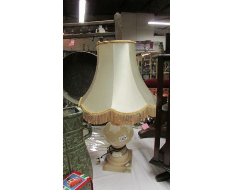 A large heavy carved pink alabaster table lamp