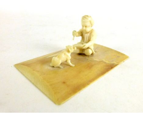 A (?) POW ivory carved model in the form of a young child and dog on a base,  l. 9 cm, w. 6 cm  CONDITION REPORT: the child's