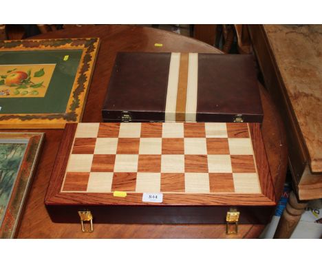 An inlaid wooden chess board set and a leatherette mounted backgammon set